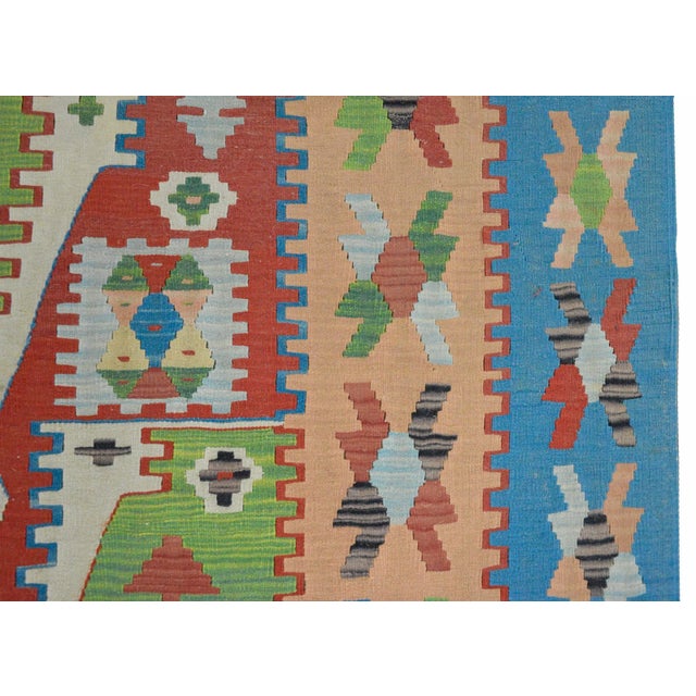 A wonderful vintage Turkish kilim rug with a complex geometric pattern with myriad stylized flowers all woven in red,...