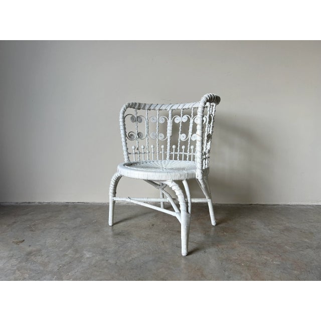 Early 1900s Heywood Wakefield style white painted wicker accent chair. Antique Victorian chair offers wicker construction...