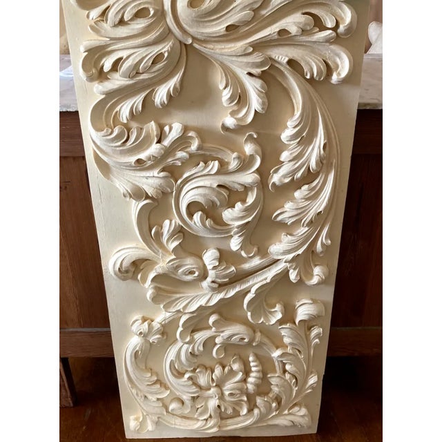 Antique wood panel with carved acanthus leaves.