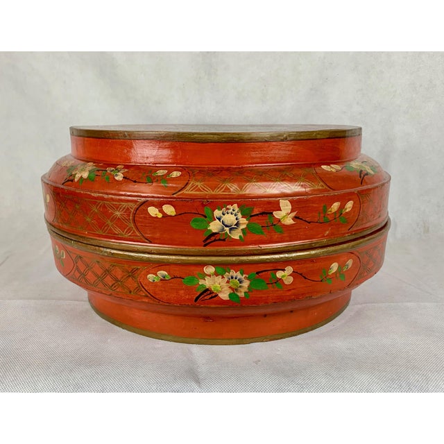 Chinese round red lacquer two part wedding box. Entirely hand decorated with a bird and flower motif on top, flowers and...