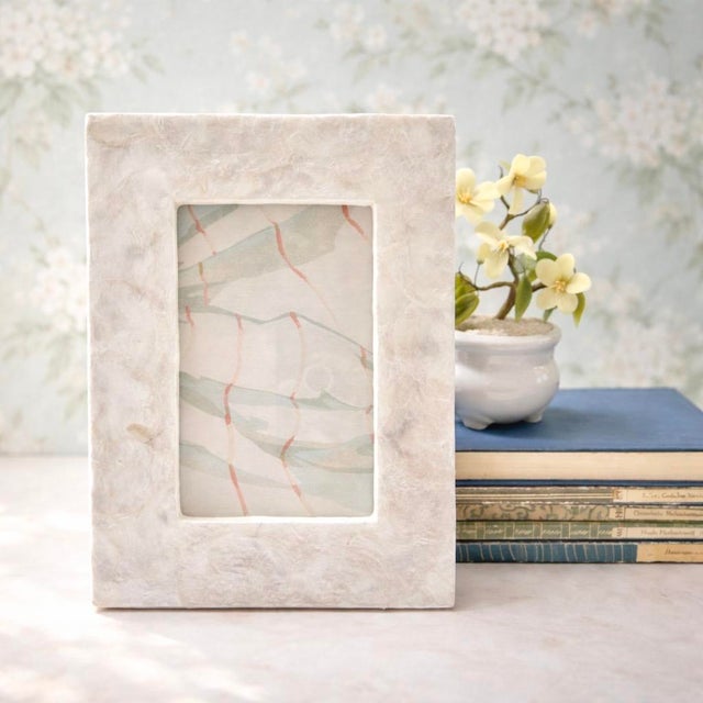 A vintage Capiz shell picture frame featuring softly iridescent panels with natural tonal variation, creating a luminous,...
