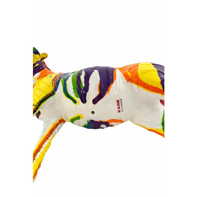 Hand-painted ceramic horse sculpture by KARE Design featuring a vibrant multicolor pop-art style glaze. A bold...