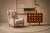 The silhouette is defined by a tall winged back, deep diamond tufting, and sharply articulated arms that create a strong...
