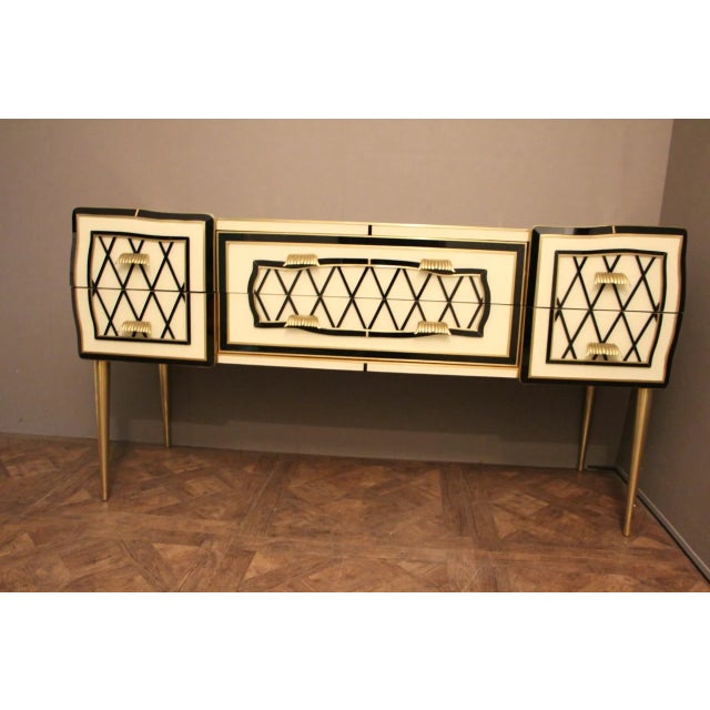 This elegant sideboard features eye-catching geometrical decor made of Murano glass plaques and brass inlay. The black...