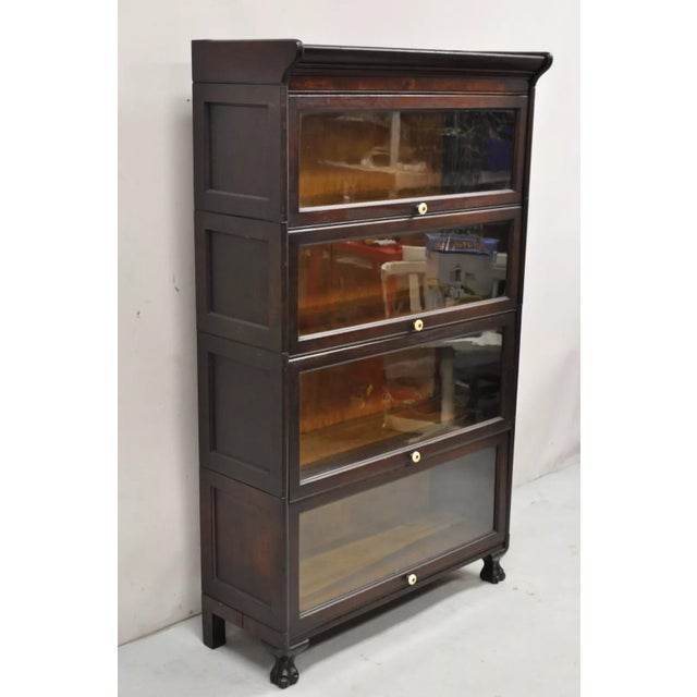Antique American Empire Style Mahogany 4 Section Stacking Barrister Bookcase. Item features carved paw feet, 4 glass...