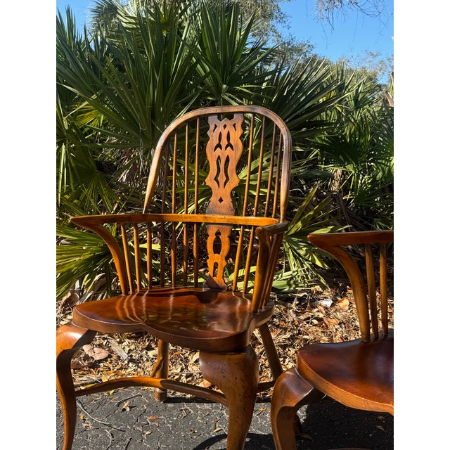 A beautiful and authentic pair of antique English Windsor armchairs featuring elegant cabriole front legs and a finely...