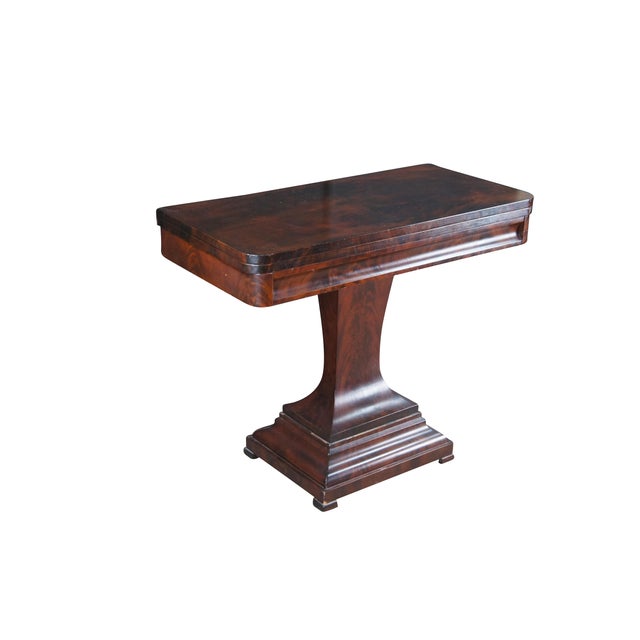 American Empire–period pedestal side table (circa 1820–1840) made from crotch mahogany. Features a rectangular top with...