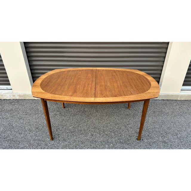 Level up family dinner with this beautiful mid century dining table. This piece features slightly curved sides with...
