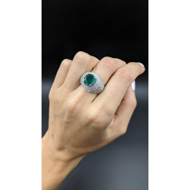 Discover the allure of our exquisite cocktail ring, featuring a captivating 6.65 carat round emerald. This vibrant green...