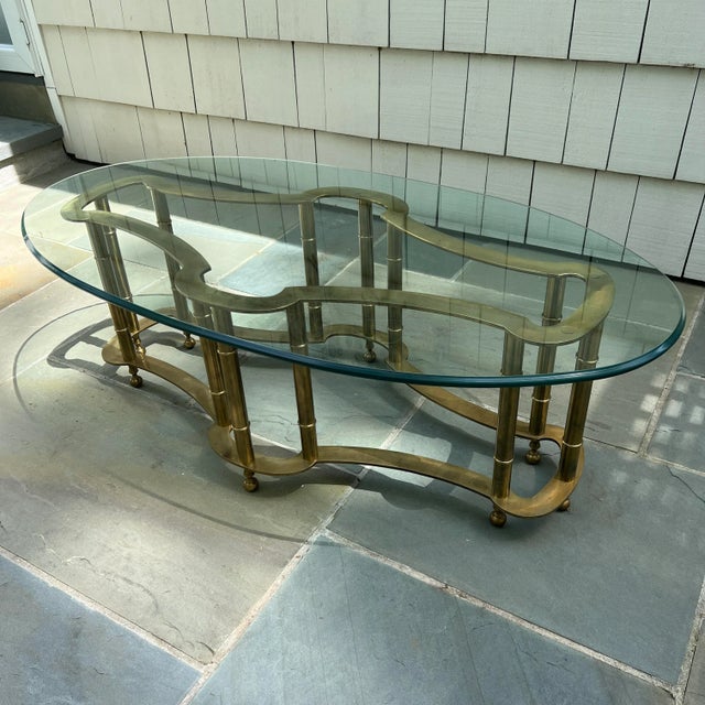 This Hollywood Regency solid brass coffee table with an oval, bevelled glass top (3/4" thick) makes a statement in any...