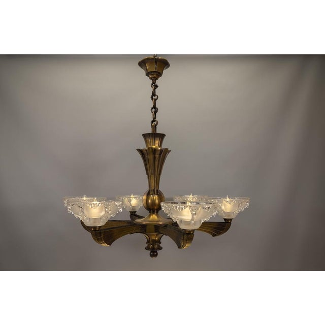 Elegant French Art Deco chandelier with six sculptural frosted glass shades and refined bronze arms, circa 1930. This...