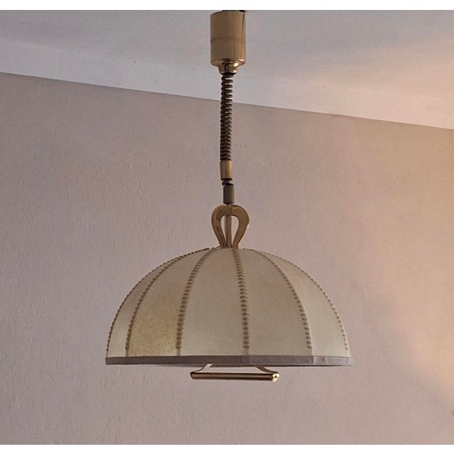 Cocoon pendant light, hand-crafted parchment with stitched leather binding on a brass frame, Italy 1950s. A rare lamp with...