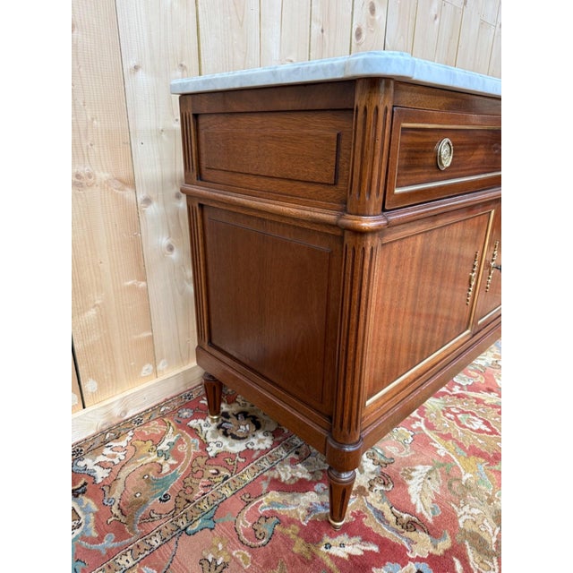 A louis xvi style two-door sideboard in solid mahogany on an oak substructure, topped with a white carrara marble slab...