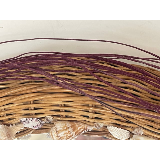 Mid century modern wicker wall mirror adorned with sea shells, sea whip branches for coastal decor.