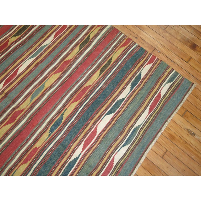 A handmade early 20th century tribal Kilim with beautiful array of colors. Measures: 5'10" x 10'1".
