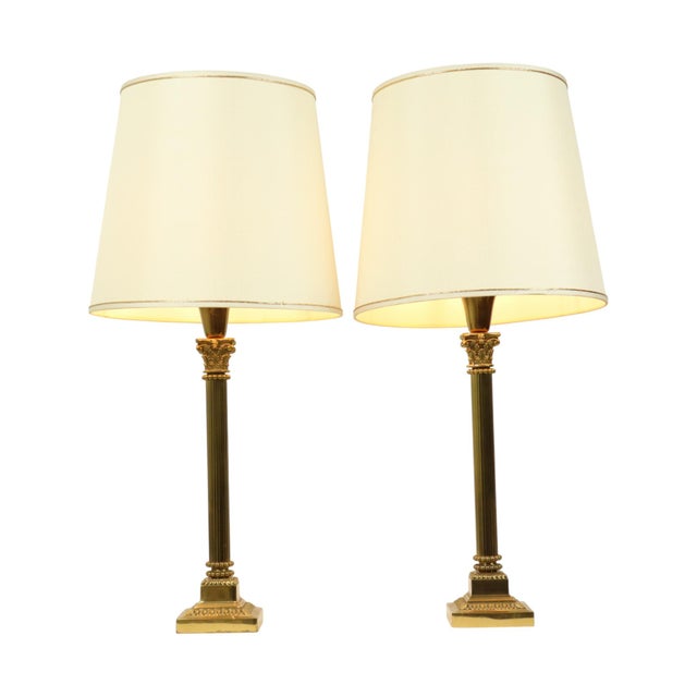 A pair of Hollywood Regency table lamps in the shape of a Corinthian column or pillar, classic lamps with round white...