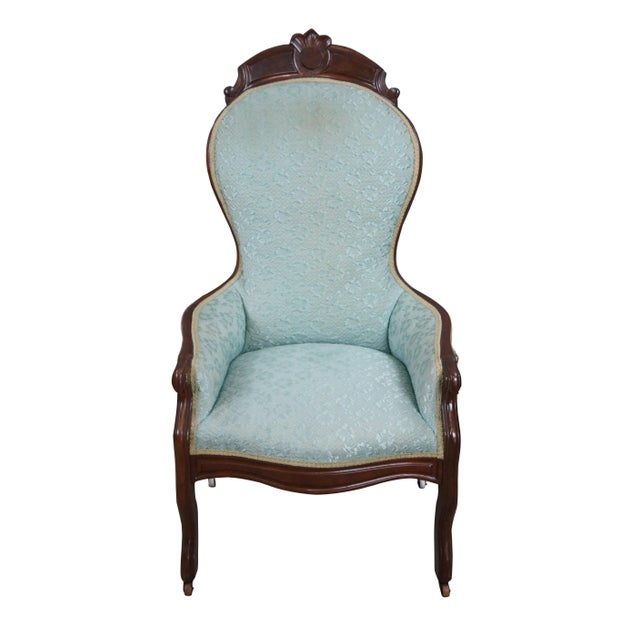 Antique Victorian balloon back arm chair. Made of walnut featuring high back with paneled foliate crest, low arms and...