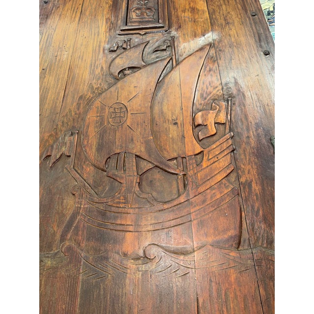 A striking and highly evocative 1920s Spanish Revival door, masterfully hand-carved from solid wood and centered with a...