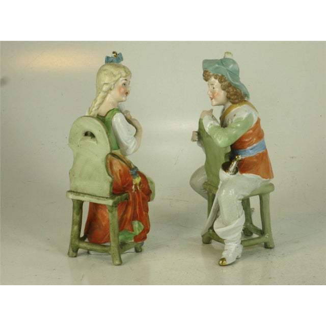 DEP Germany Renaissance figurines featuring a man and a woman sitting on chairs, hand-painted in a multi-color design....