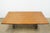 Vintage dining table featuring a warm wood top and an ornate iron base with dramatic scrollwork detailing. The rectangular...