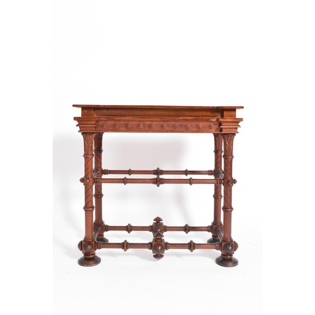 Arts & crafts wooden console table on four turned wood legs with a floral pattern and joined by a spacer. England, 1910s....