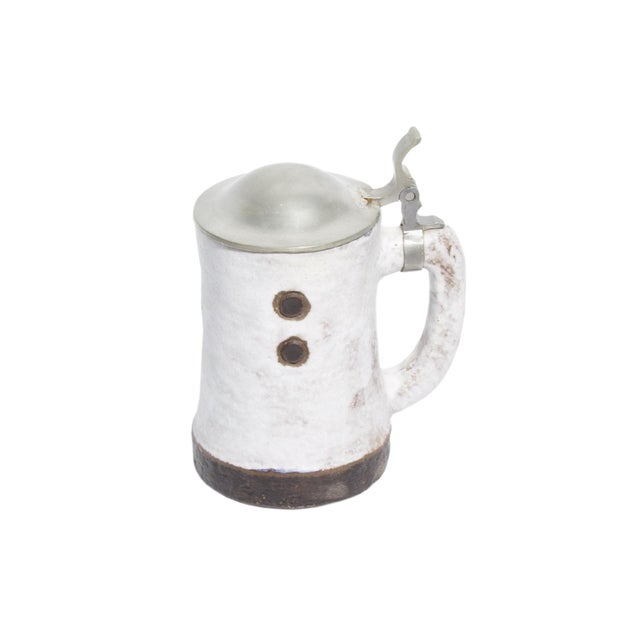 A West German "Domino" beer stein produced by the West German pottery studio Ceramano. This stein features a white...