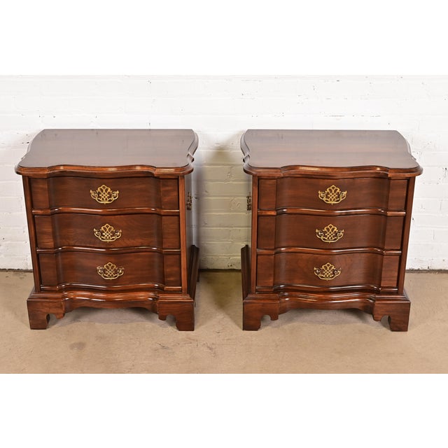 A beautiful pair of Georgian or Chippendale style three-drawer nightstands or bachelor chests By Harden Furniture USA,...