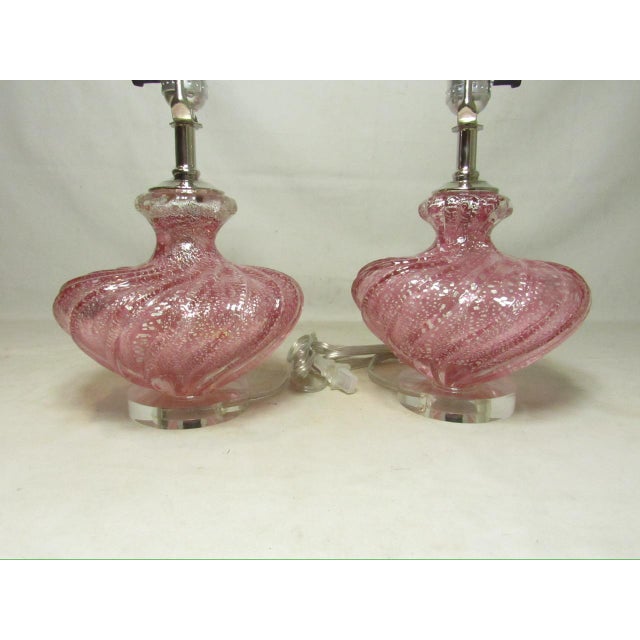 Pair of pink Murano art glass lamps, c.1950’s Featuring prominent swirled ribs and a distinctive pink color with silver...