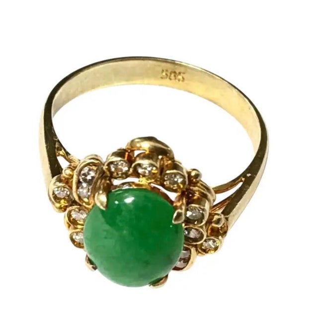 Elegant vintage 14K Gold Oval Jadeite and Diamond Cocktail Ring. Ring features a smooth center oval jadeite gem in a rich...