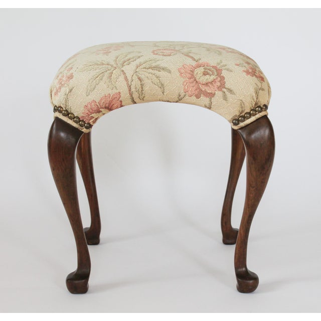 Vintage Queen Anne-style footstool featuring an elegant floral upholstered seat and curved cabriole legs. No makers mark....