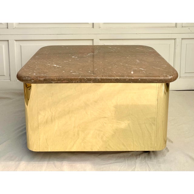 This striking vintage brass clad coffee table features a sculptural rounded form paired with a substantial thick marble...