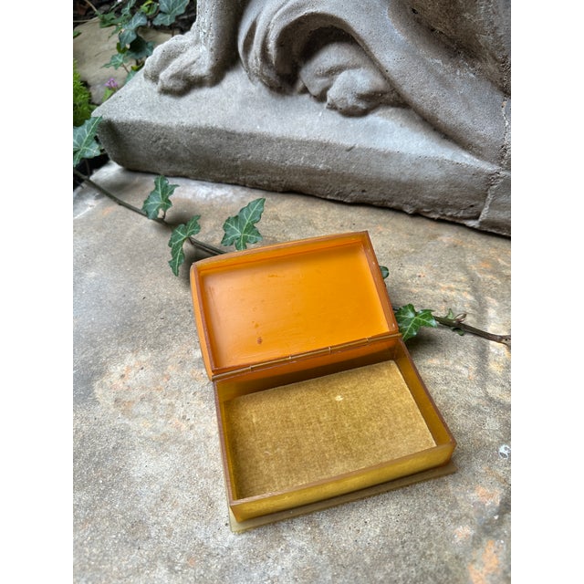 Striking vintage Art Deco Bakelite hinged box featuring a warm butterscotch amber body and a marbled cream lid accented...