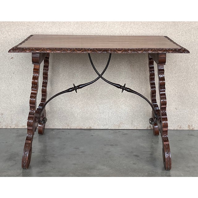 Side table of walnut with carved lyre legs with carved edges in top. The lyre legs are carved inside and outside....