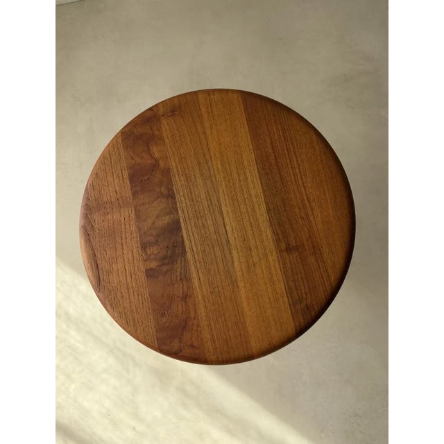The strength of this small table lies primarily in its form. A round top with a full, rounded edge rests on a central...