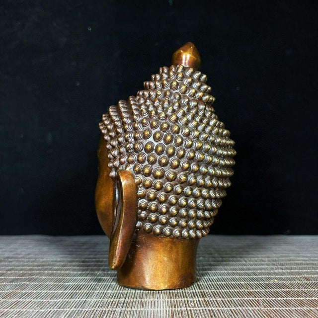 This impressive vintage Chinese sculpture features a finely cast bronze head of Shakyamuni Buddha. The piece is modeled...