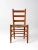 An antique ladder-back chair in a classic French country style, featuring a clean ladder back and woven rush seat. The...