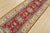 A tribal Caucasian Kazak runner hand-knotted with fine wool on a cotton foundation. This rug features a row of medallions...