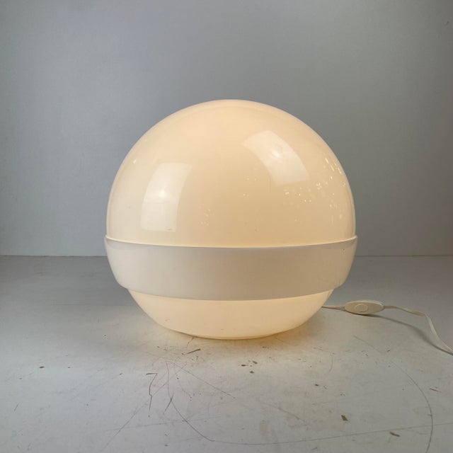 Elegant Space-Age table lamp crafted in white translucent methacrylate, featuring two interlocking hemispheres that form a...
