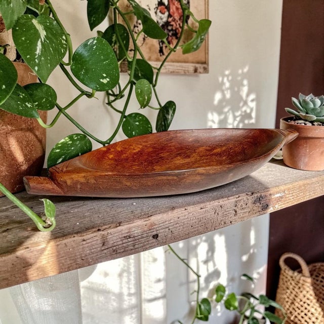 This exquisite African Carved Wooden Paddle Bowl with Handles is a stunning blend of artistry and functionality, perfect...