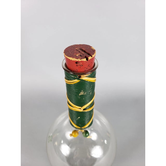 Mid-century glass flask with cork top and green decorative trim.