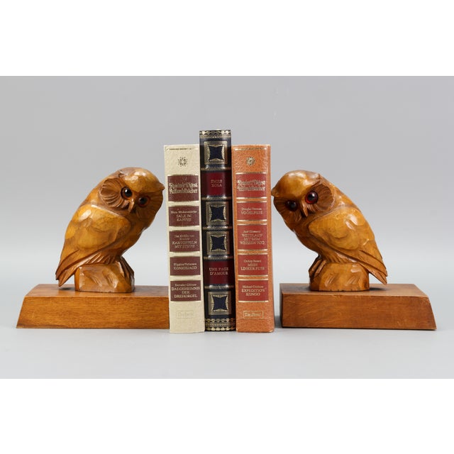 A charming pair of linden wood bookends with carved figurines of Owls with beautiful orange eyes, Germany, circa the...