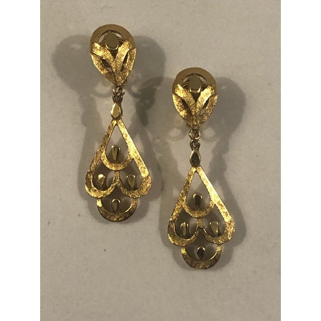 This fabulous pair of 1970s Trifari Gold Art Deco Dangle Earrings is sure to garner lots of oohs and aahs. The...