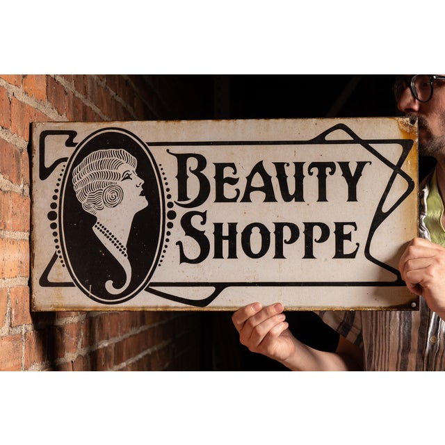 Double-sided porcelain enamel projecting trade sign for a beauty shop, featuring a striking Art Deco portrait of a...