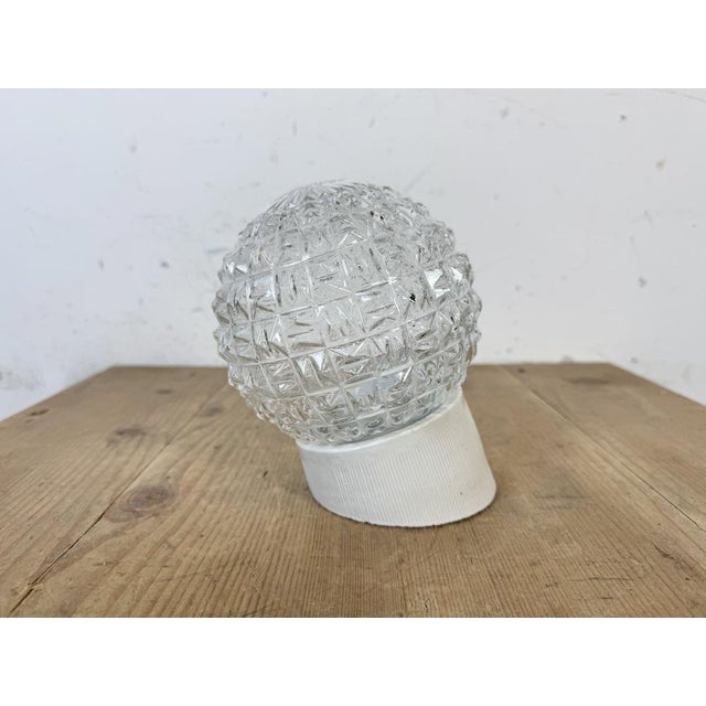 Vintage industrial light made in former Czechoslovakia the 1970s. It features a white porcelain wall mounting and a glass...