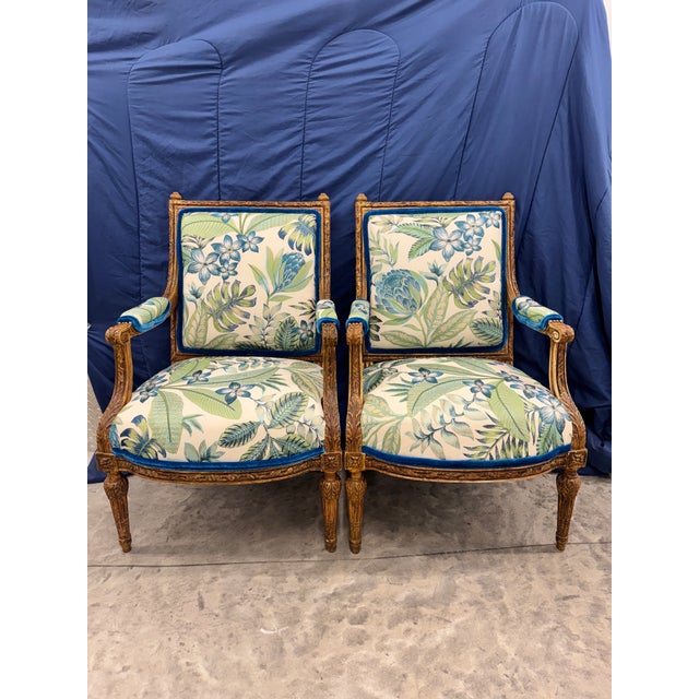 Lovely pair of newly reupholstered embroidered floral French Louis XVI Slightly Oversized lounge chairs. Gorgeous gilt...