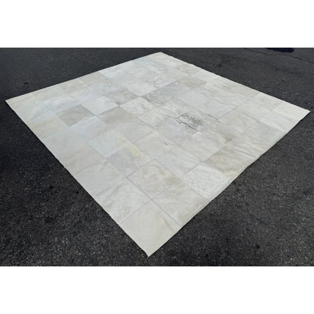 Design Plus Gallery presents an 8ft Hair on Hide Patchwork Area Rug in Silver Gray. The rug is arranged in a grid pattern...