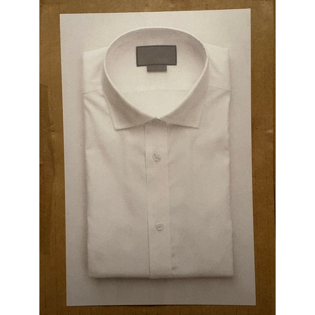 A simple crisp white shirt, neatly folded in a reproduction print made by the artist’s studio based on his original...