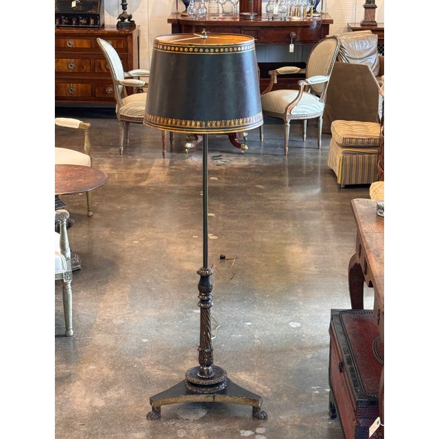 A good-looking floor lamp with a carved wooden base painted black with gilt edges. The base is triangular with three paw...