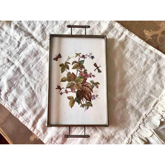 An elegant rectangular tray dating back to the mid-20th century, featuring a large central ceramic tile set in a...