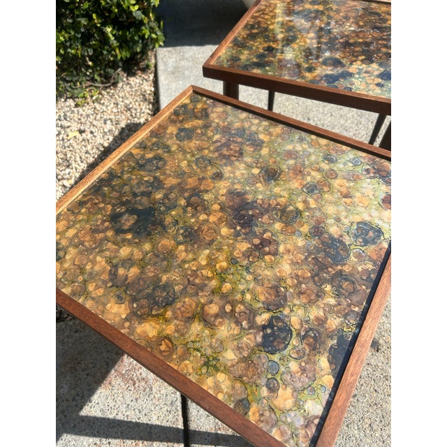Set of two vintage nesting side tables with square tops featuring multicolor resin with layered tonal variation and...
